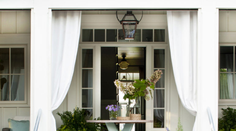 Close up of back porch with table and white curtains