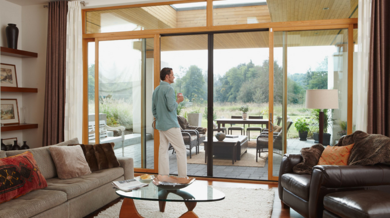 Man standing in front of large sliding doors with Phantom retractable door screens