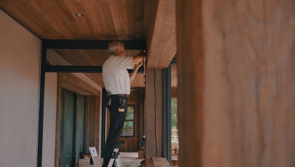 Man installation retractable motorized screens on patio